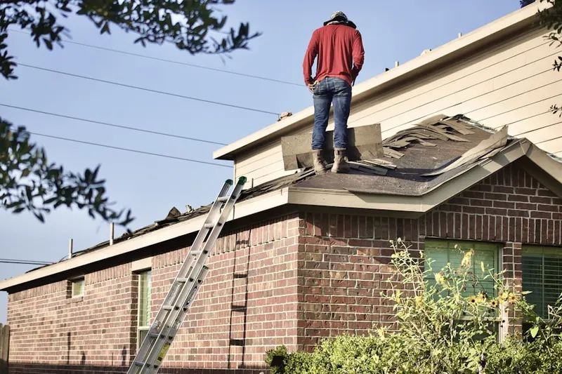 Professional roofer working on a residential roof in Belle Haven